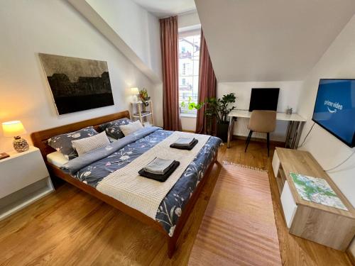 a bedroom with a bed and a desk in it at Artystyczna przestrzeń z widokiem na jeziora in Iława