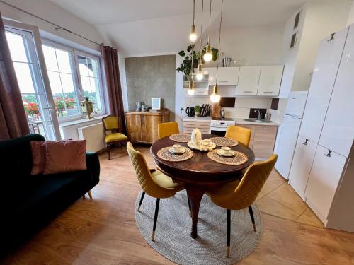 a kitchen and dining room with a table and chairs at Artystyczna przestrzeń z widokiem na jeziora in Iława