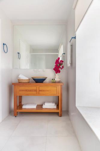 a bathroom with a wooden vanity with a mirror at Captain Hook in Hydra