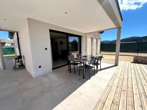 a dining room with a table and chairs on a patio at Villa L'Olivier in Vallon-Pont-dʼArc