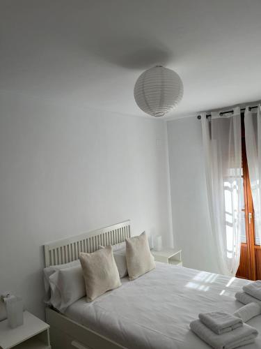 a white bedroom with a large bed with white pillows at La Casa del Tambor in Córdoba