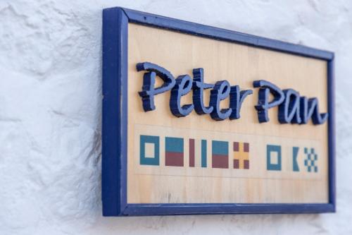 a sign for a peter pan sign on a wall at Captain Hook in Hydra
