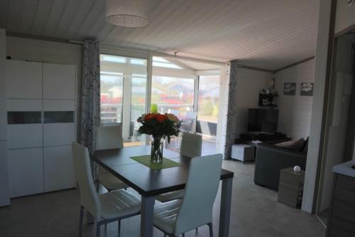 a dining room table with white chairs and a vase of flowers at Chalet in Hudimesnil