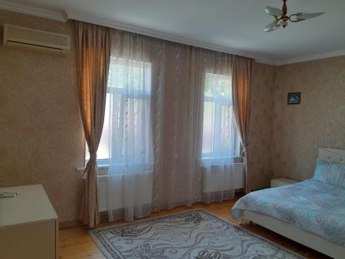 a bedroom with a bed and a window with curtains at Gabala villa Exceptional in Gabala