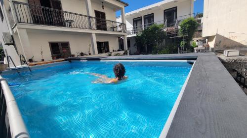 a woman is in a swimming pool in a house at Hostel Center in Ulcinj