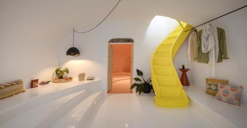 a room with a yellow door and a white wall at Sophia Luxury Suites in Imerovigli