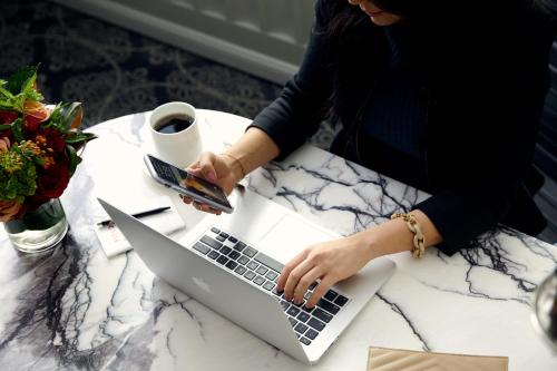 a woman sitting at a table using a laptop computer at Loews Regency New York Hotel in New York