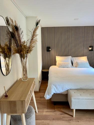 a bedroom with a bed and a table with a vase at Luxe Boshuisje met Privé Wellness & Jacuzzi op de Veluwe in Ermelo