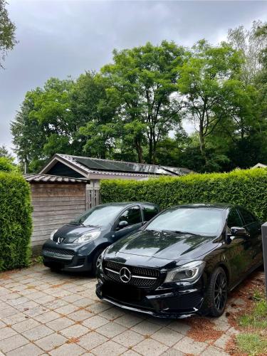 two cars parked in front of a garage at Luxe Boshuisje met Privé Wellness & Jacuzzi op de Veluwe in Ermelo