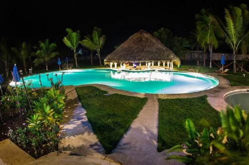 a swimming pool at night with a gazebo at Hotel Cafe del Sol in Monterrico