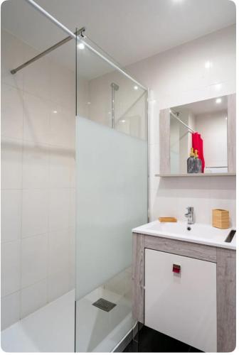 une salle de bain blanche avec un lavabo et une douche dans l'établissement Spacieux 3 pièces à 200m des plages, à Antibes