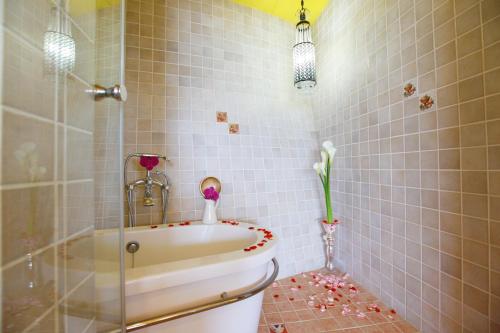 a bathroom with a tub with flowers on the floor at Hao Wang Jiao House in Datong