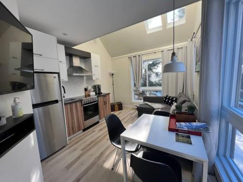 a kitchen and living room with a table and chairs at Modern Chalet in the Mont Tremblant Ski Village in Mont-Tremblant