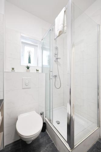 a white bathroom with a shower and a toilet at Classy apartments in city centar in Zadar