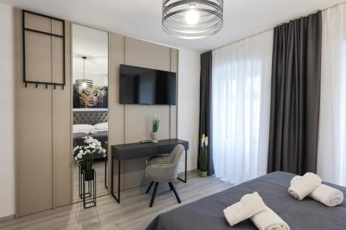 a bedroom with a bed and a desk with a computer at Classy apartments in city centar in Zadar
