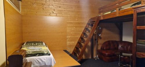 a bedroom with a bunk bed and a chair at Hotel Corrado in Ostrava