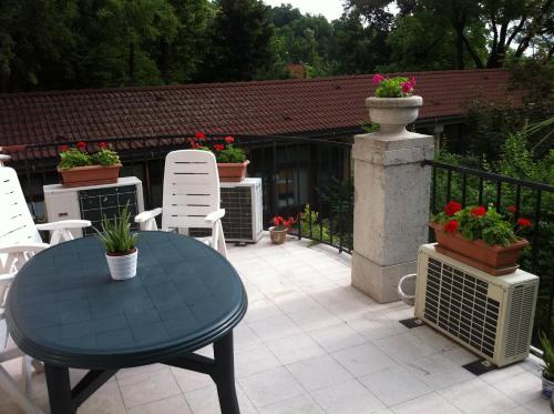 a patio with a blue table and chairs and flowers at Kalmár Panzió in Budapest