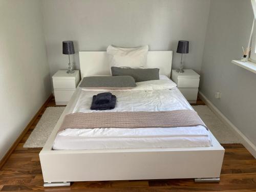 a white bed in a bedroom with two night stands at Wohnung 21 in Zeitlofs
