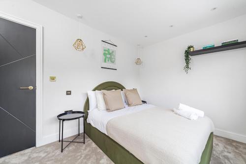 a bedroom with a bed with white sheets and pillows at Arte Stays - Serviced Apartments for Leisure and Business - Private Parking - 12 minutes walking from Wembley Stadium in London