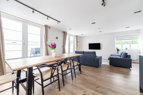 a living room with a large wooden table and chairs at Arte Stays - Serviced Apartments for Leisure and Business - Private Parking - 12 minutes walking from Wembley Stadium in London