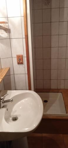 La salle de bains est pourvue d'un lavabo blanc et d'une baignoire. dans l'établissement Maison de village avec jardin, à Saint-Louis-et-Parahou