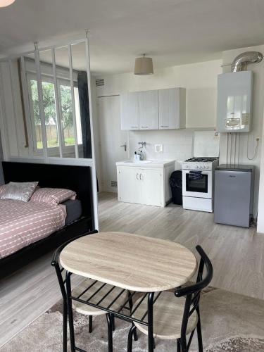 un salon avec une table et un lit dans l'établissement Apparemment Rennes, à Saint-Jacques-de-la-Lande