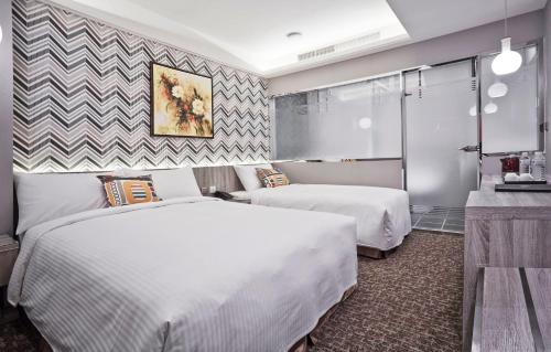 a hotel room with two beds and a counter at V-one Hotel - Ningxia No. 2 Inn in Taipei