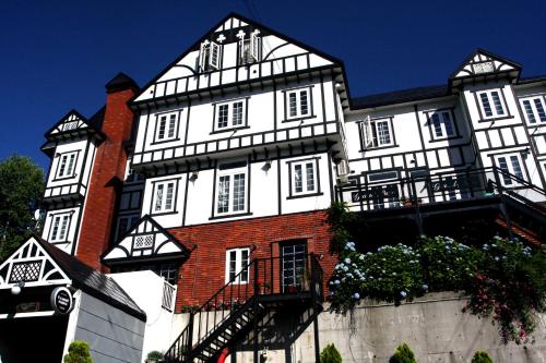 a large white and black building with a balcony at Grandpapa in Kutchan