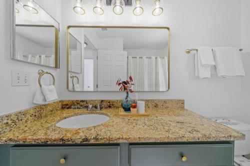 a bathroom with a sink and a large mirror at Stunning 4-bedroom Villa w/ Pool - Close to Disney Parks and Gulf Courses! in Davenport