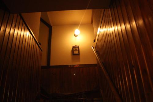 a bathroom with a mirror and a light on the wall at Grandpapa in Kutchan