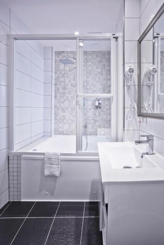 a white bathroom with a tub and a sink at V-one Hotel - Ningxia No. 2 Inn in Taipei