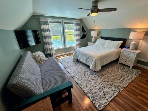 a bedroom with a bed and a tv and a couch at 64J Stunning views, close to attractions! 20 min to Bretton Woods. Pool & gym passes! in Whitefield