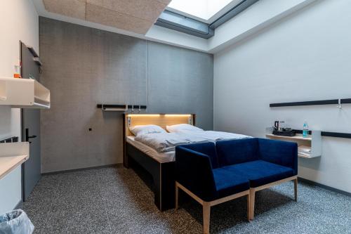 a bedroom with a bed and a blue chair at Das Kittchen in Wismar