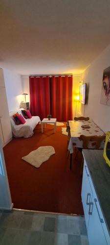 - un salon avec un rideau rouge et un canapé dans l'établissement Studio montagne 4 pers, au Corbier