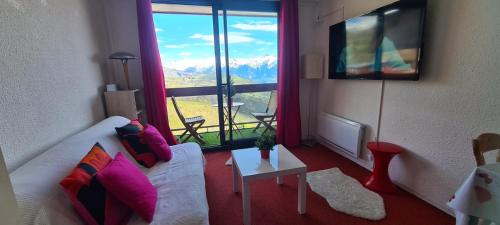 un salon avec un canapé blanc et une grande fenêtre dans l'établissement Studio montagne 4 pers, au Corbier