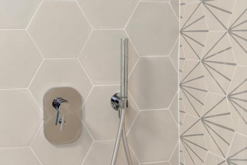 a shower in a bathroom with white tiles at Dal Pernè in Volastra