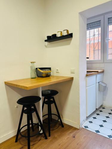 a kitchen with two bar stools and a counter at Casa Leo in Almería
