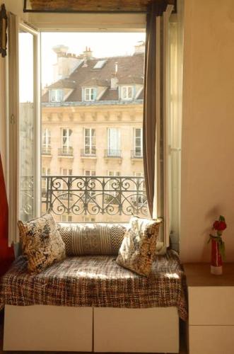 une fenêtre avec un banc devant une fenêtre dans l'établissement Amazing Rooftop Odeon Luxembourg, à Paris