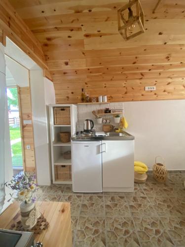 a kitchen with a white refrigerator and wooden ceilings at Apartment & Rooms Sweet Dreams in Žabljak