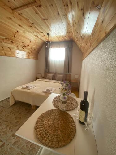 a room with two beds and a table with a bottle of wine at Apartment & Rooms Sweet Dreams in Žabljak