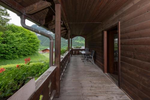 a porch of a wooden house with a table and chairs at CPM Apartments in Grindelwald