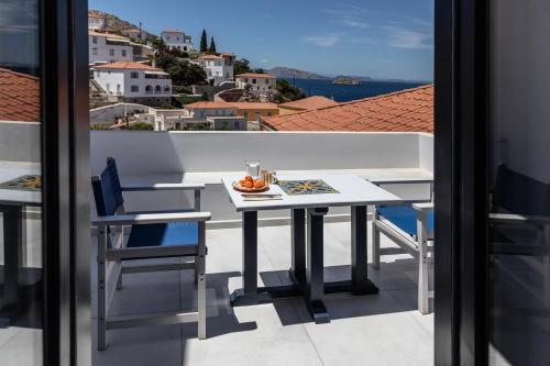 a table and chairs on a balcony with a view at Captain Hook in Hydra