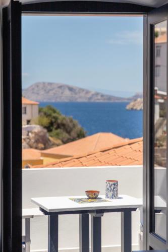 a table on a balcony with a view of the water at Captain Hook in Hydra