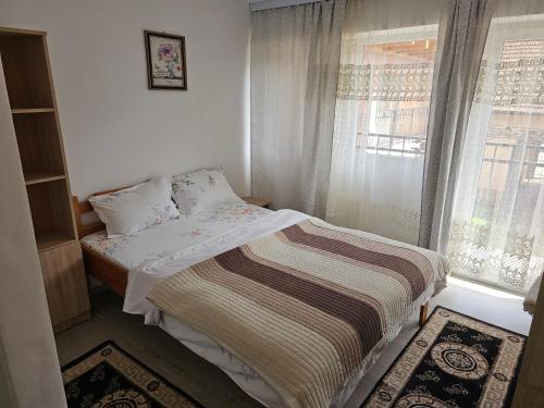 a small bedroom with a bed and a window at Casa Izbuc in Izbuc