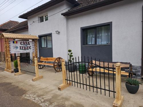 a fence in front of a house with a sign at Casa Izbuc in Izbuc