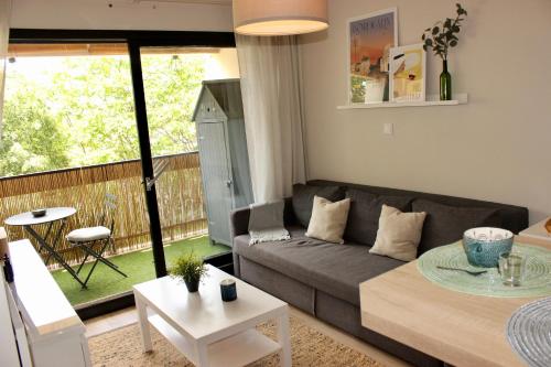 a living room with a couch and a table at Le Petit Moulin in Gradignan