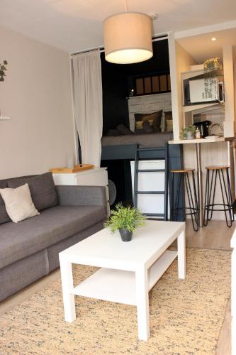 un salon avec un canapé et une table dans l'établissement Le Petit Moulin, à Gradignan