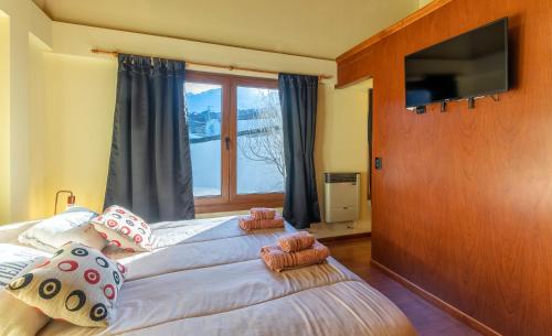 a bedroom with two beds and a large window at Happy Guest Apart 87 in Ushuaia