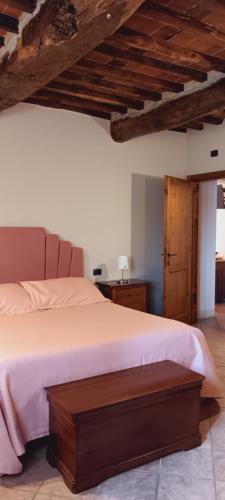a bedroom with a large bed with a wooden ceiling at La Torre wine resort in Montecarlo