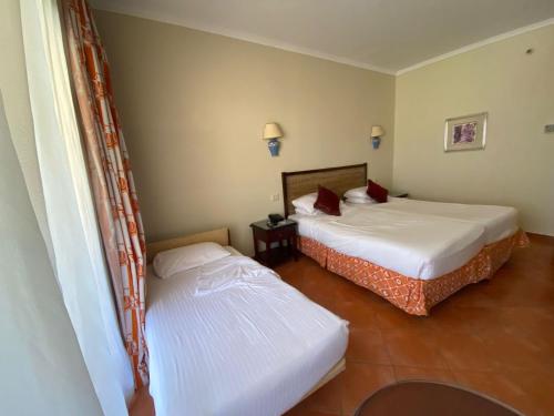 two beds in a hotel room with at فندق بورتو مارينا - غرفة فندقية بخدمة فندقية in El Alamein